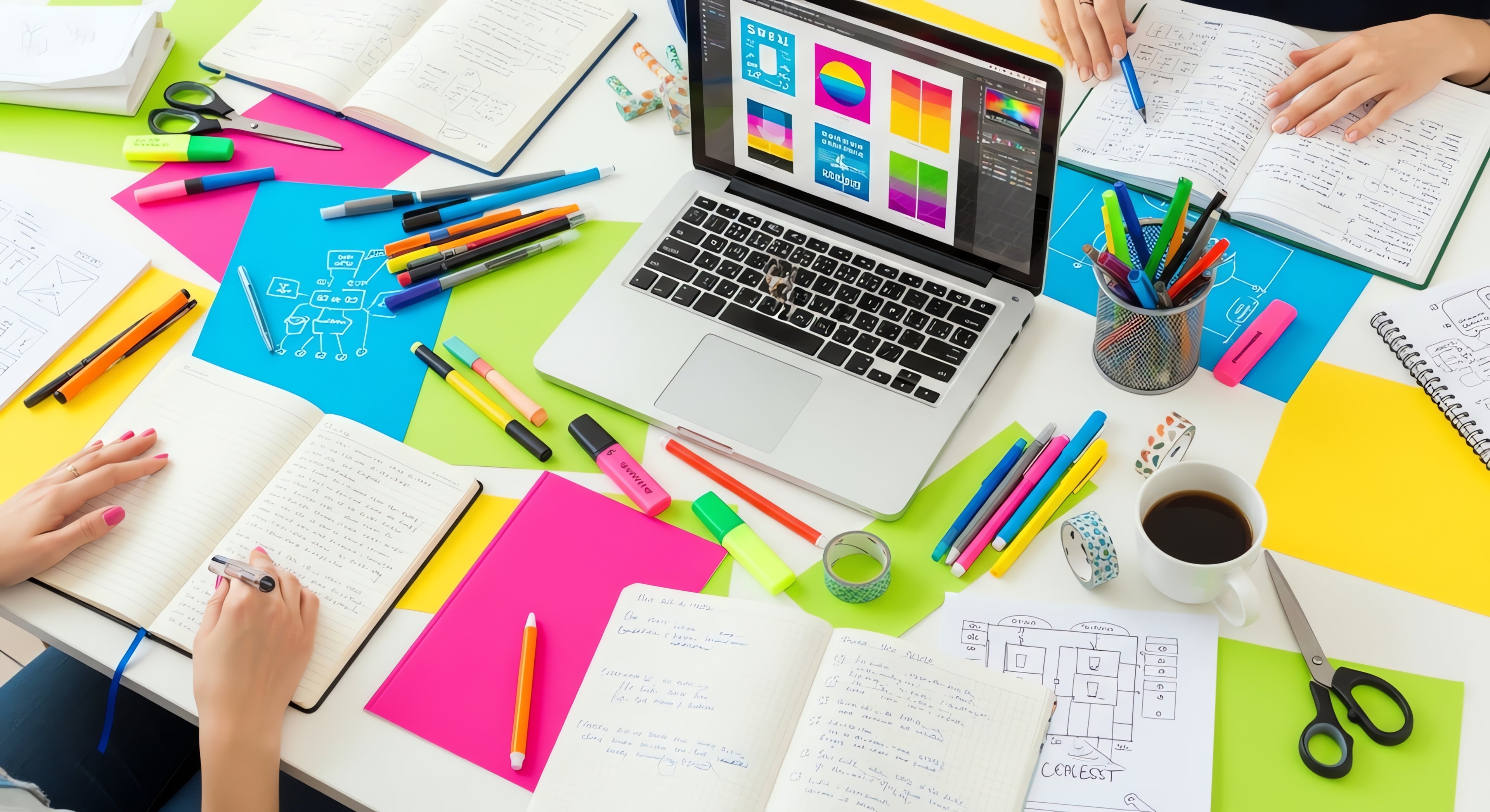 Colorful desk with laptop, notebooks, and stationery items